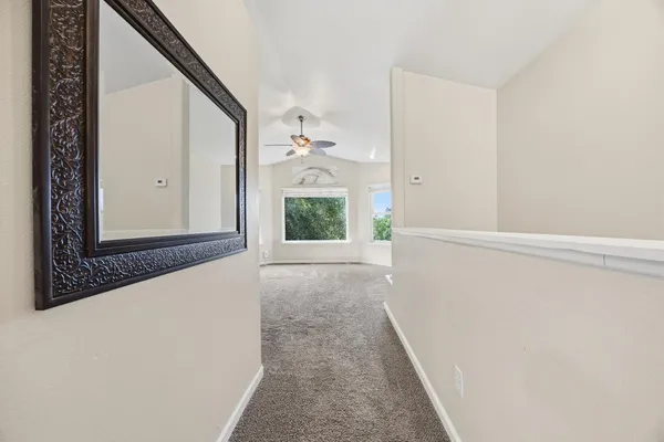 a view of a hallway with wooden floor and a living room