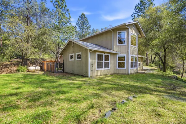 a view of a big house with a big yard and large trees