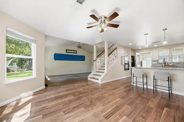 a view of a livingroom with wooden floor and a ceiling fan