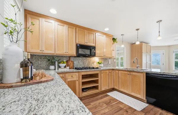 a kitchen with stainless steel appliances granite countertop a stove a sink and a microwave