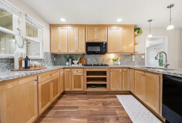 a kitchen with granite countertop a stove a sink and a microwave