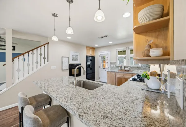 a kitchen with stainless steel appliances kitchen island granite countertop a sink and cabinets
