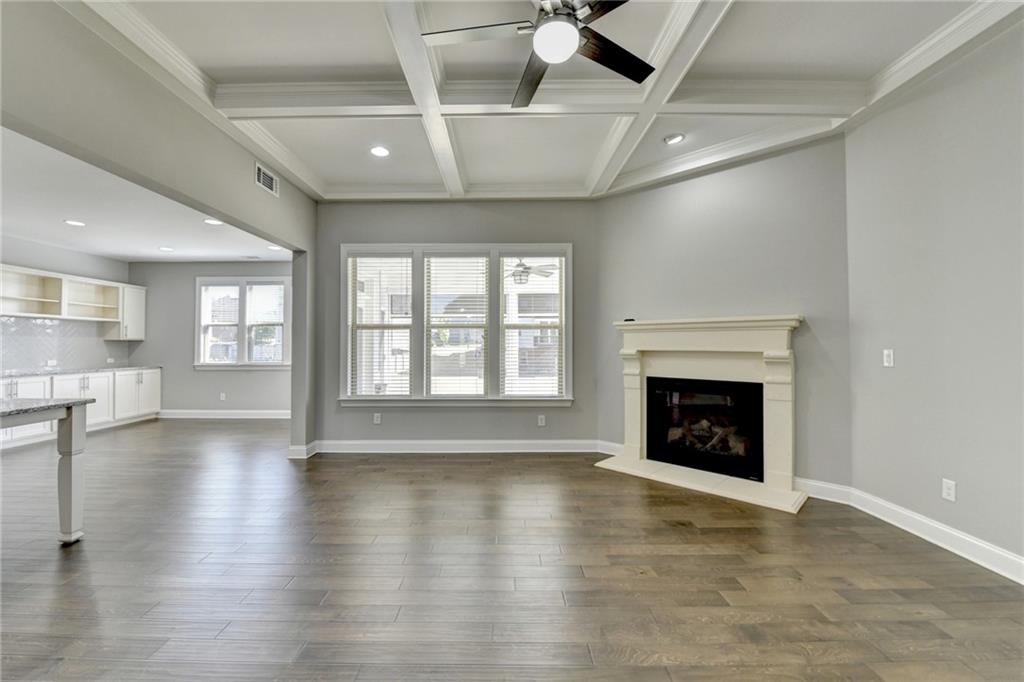 4217 Heisenberg Lane Suwanee, GA 30024 - Photo 18 of 72 an empty room with wooden floor fireplace and windows