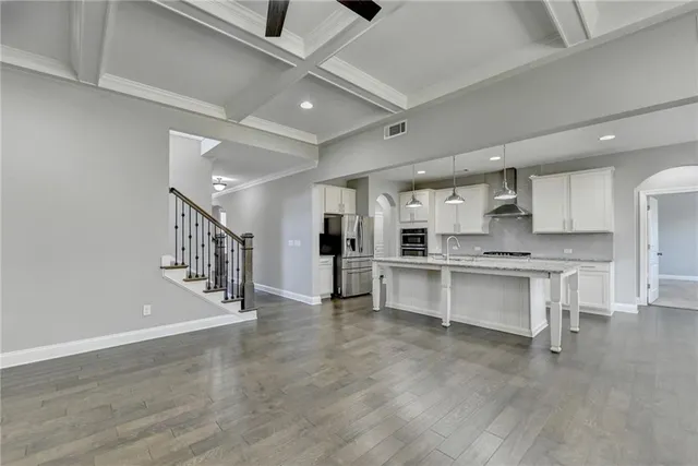 a kitchen with granite countertop a sink stove and refrigerator