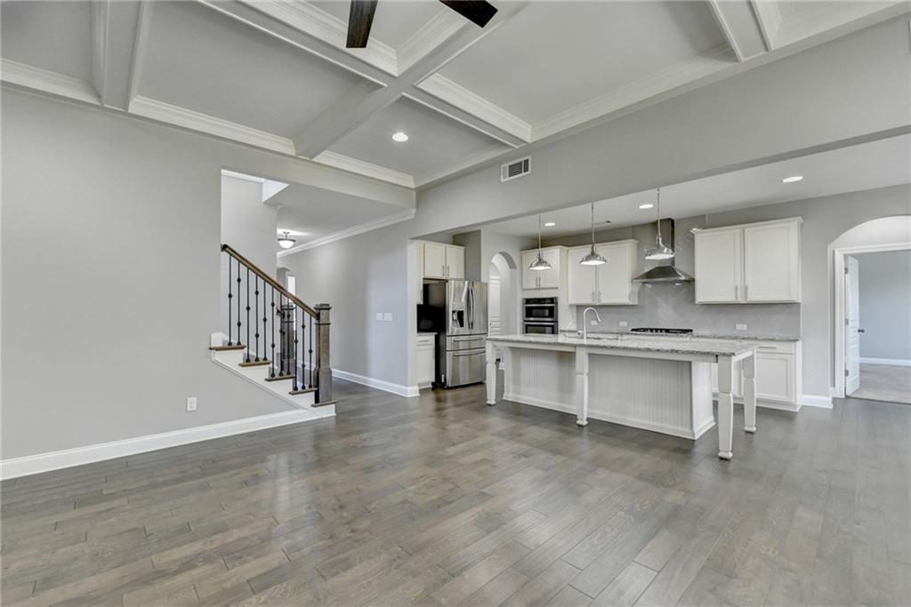 4217 Heisenberg Lane Suwanee, GA 30024 - Photo 20 of 72 a large white kitchen with white cabinets and stainless steel appliances