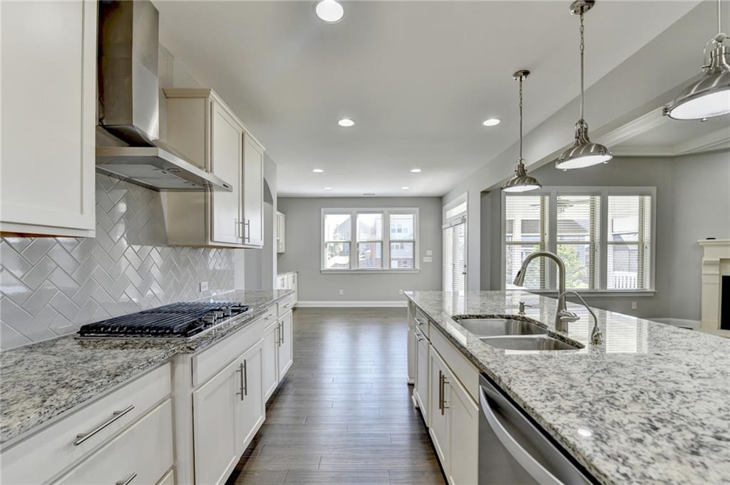 4217 Heisenberg Lane Suwanee, GA 30024 - Photo 26 of 72 a kitchen with granite countertop a sink stove and refrigerator