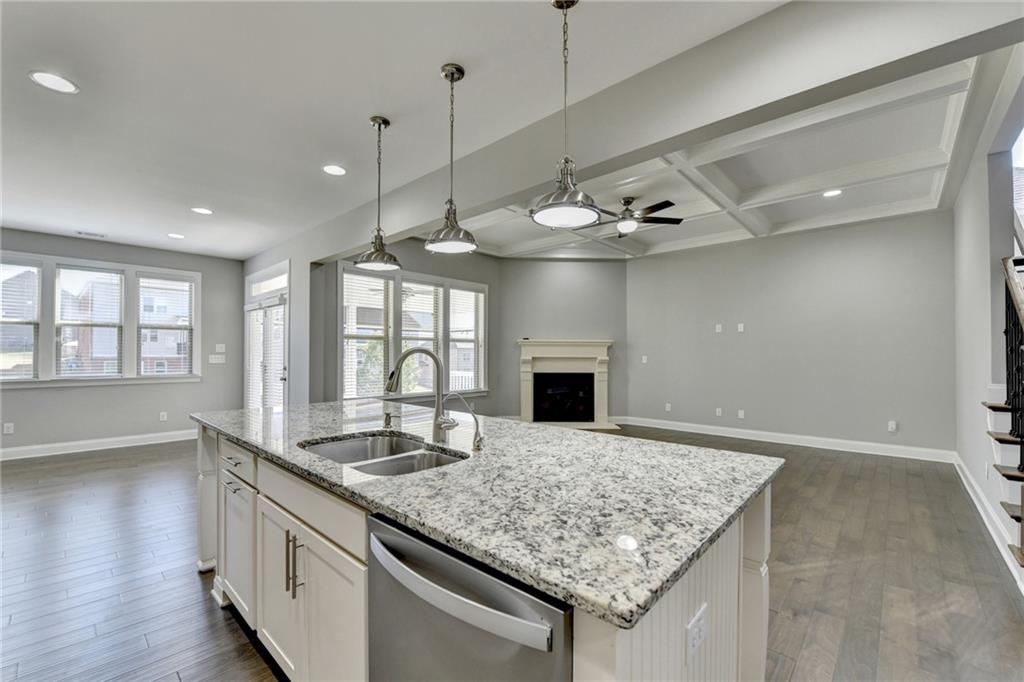 4217 Heisenberg Lane Suwanee, GA 30024 - Photo 27 of 72 a kitchen with kitchen island granite countertop a stove and a sink