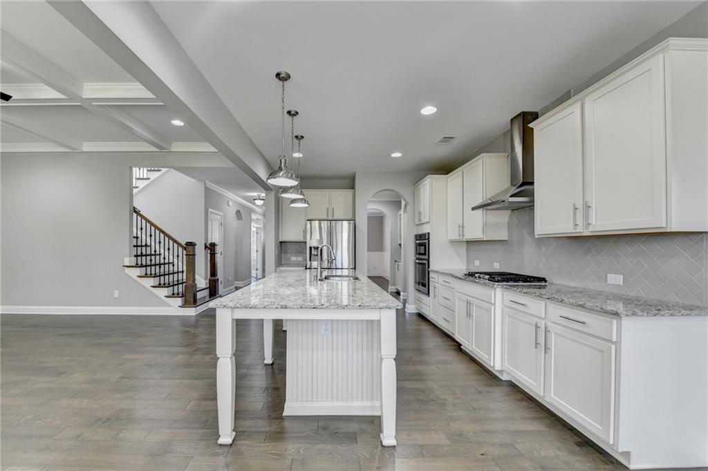 4217 Heisenberg Lane Suwanee, GA 30024 - Photo 29 of 72 a large kitchen with stainless steel appliances kitchen island granite countertop a stove and a sink