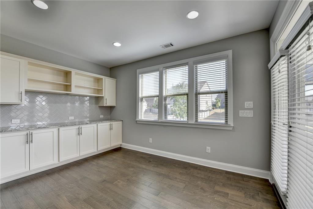 4217 Heisenberg Lane Suwanee, GA 30024 - Photo 30 of 72 a kitchen with granite countertop white cabinets and white appliances