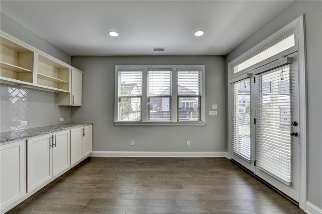 4217 Heisenberg Lane Suwanee, GA 30024 - Photo 31 of 72 a view of a kitchen with a sink dishwasher and wooden cabinets