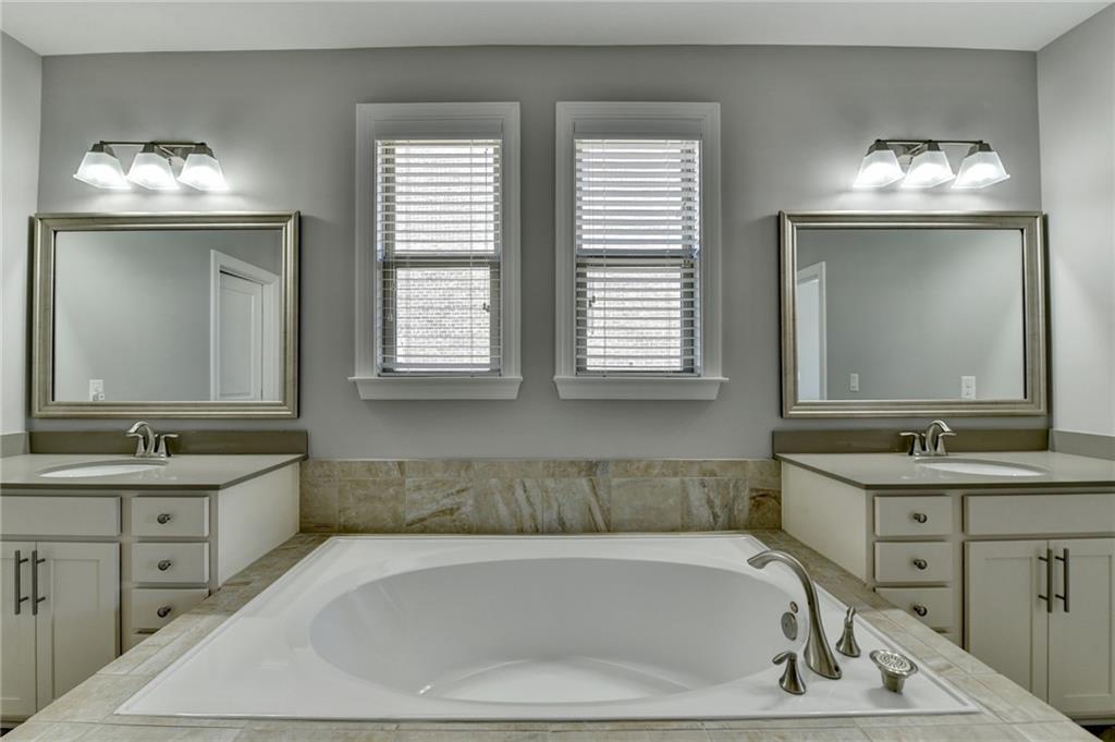 4217 Heisenberg Lane Suwanee, GA 30024 - Photo 38 of 72 a bathroom with a tub sink and mirror