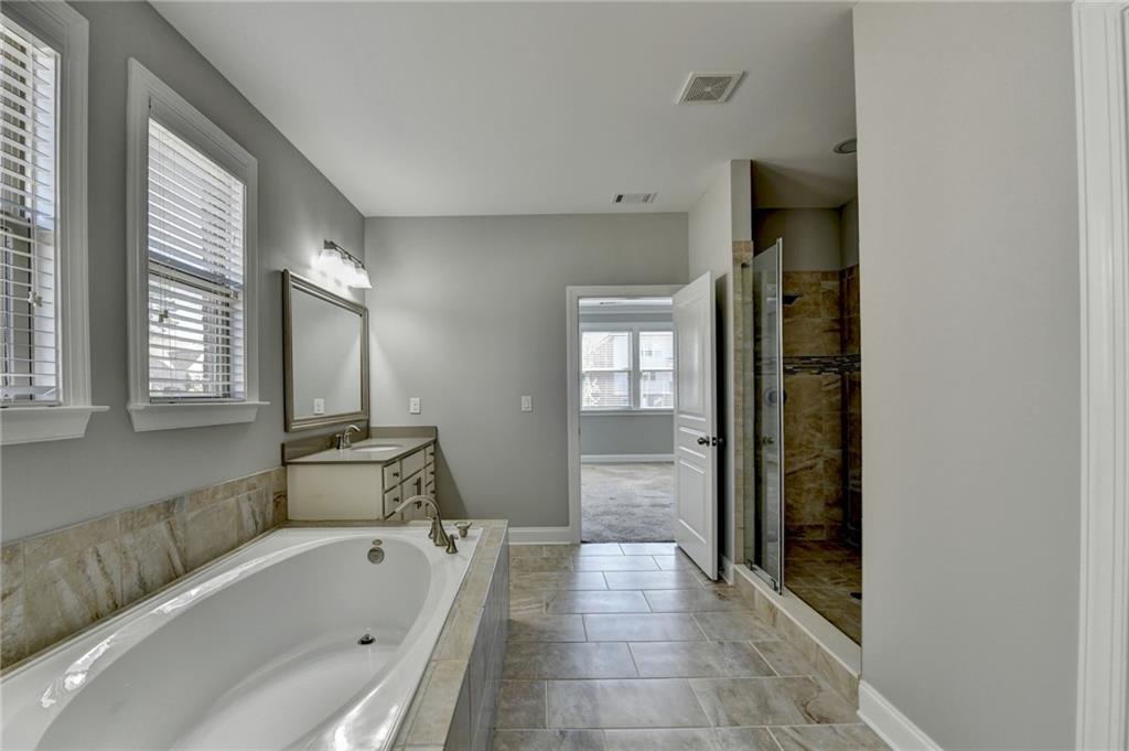 4217 Heisenberg Lane Suwanee, GA 30024 - Photo 39 of 72 a bathroom with a bathtub and a shower