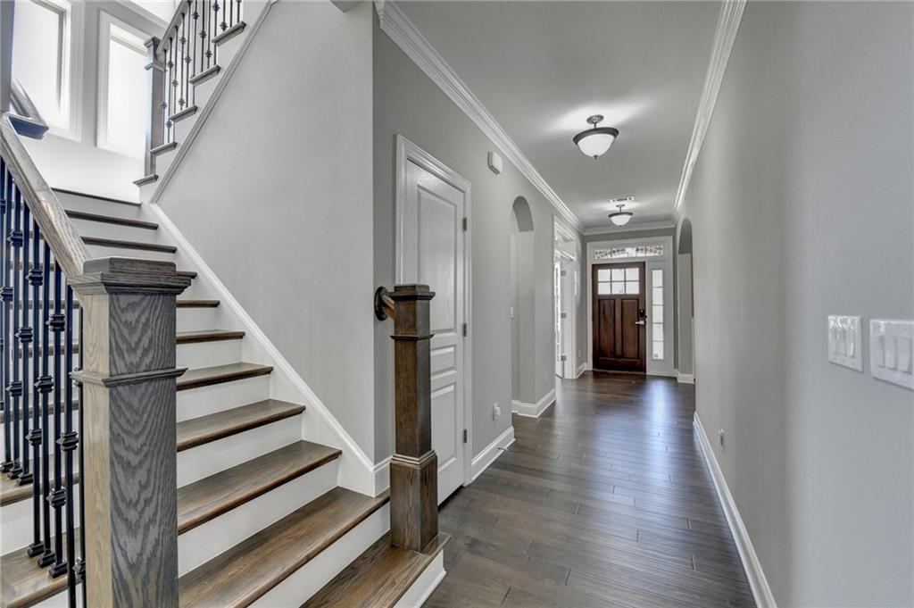 4217 Heisenberg Lane Suwanee, GA 30024 - Photo 41 of 72 a view of a hallway with wooden floor and entryway