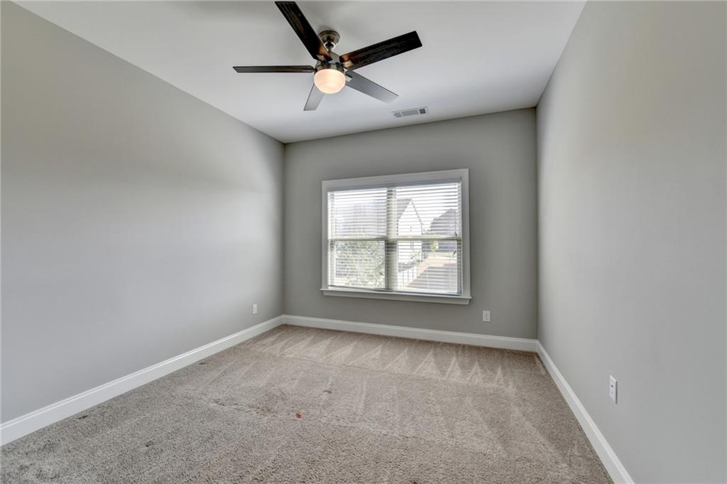 4217 Heisenberg Lane Suwanee, GA 30024 - Photo 49 of 72 an empty room with a ceiling fan and window