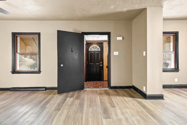 a view of a hallway with wooden floor and closet