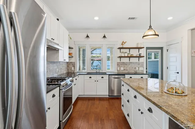 a kitchen with stainless steel appliances granite countertop a sink stove and refrigerator