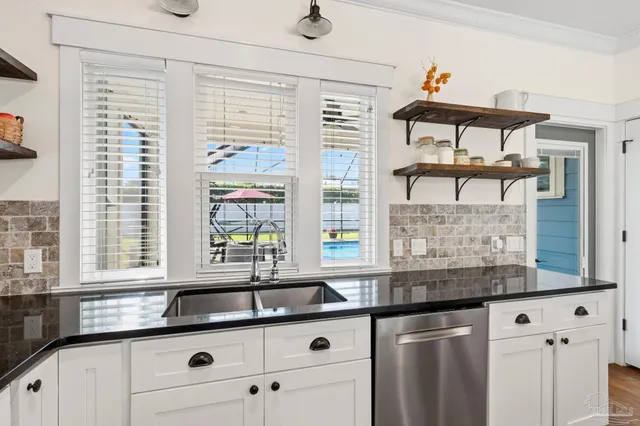 a kitchen with stainless steel appliances granite countertop a sink and a window
