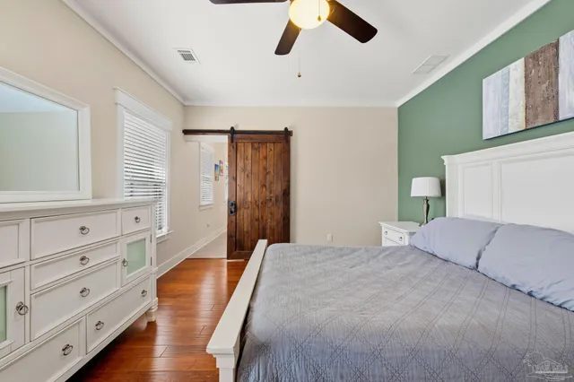 a bedroom with a bed and a flat tv screen on dresser