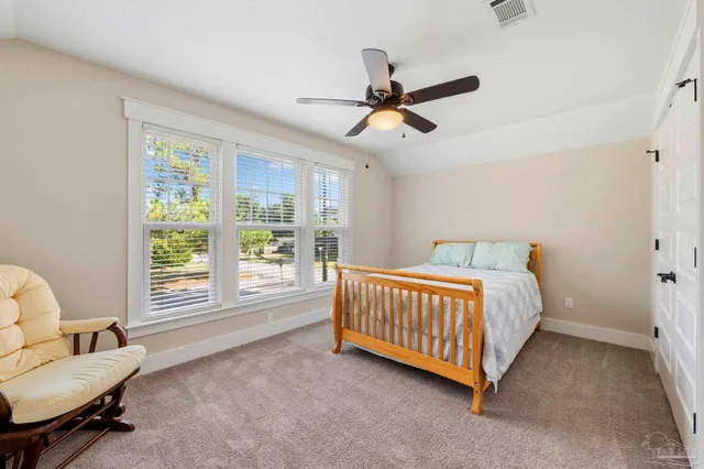 a bedroom with a bed and a chandelier fan