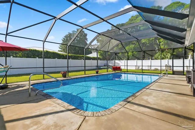 a view of a backyard with swimming pool and outdoor seating