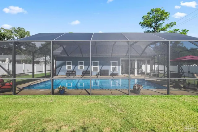 a view of a house with a backyard and a tree