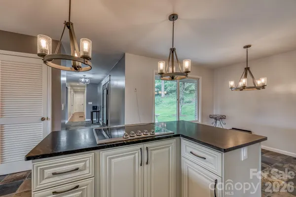 a kitchen with granite countertop a sink and chandelier