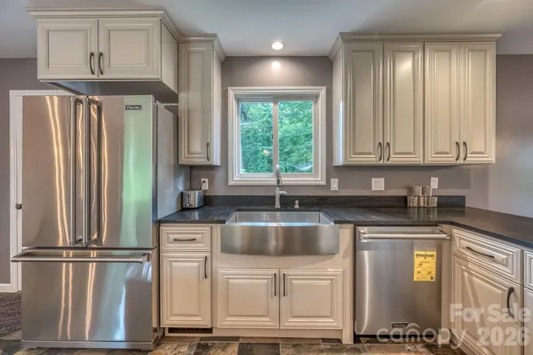 a kitchen with stainless steel appliances granite countertop a refrigerator sink and cabinets