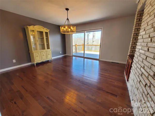 an empty room with wooden floor and window