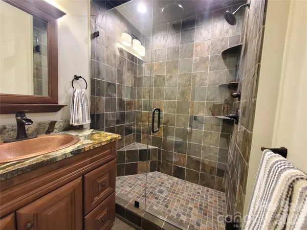 a bathroom with a granite countertop sink a toilet and shower