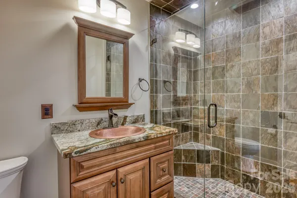 a bathroom with a granite countertop sink a toilet and a mirror