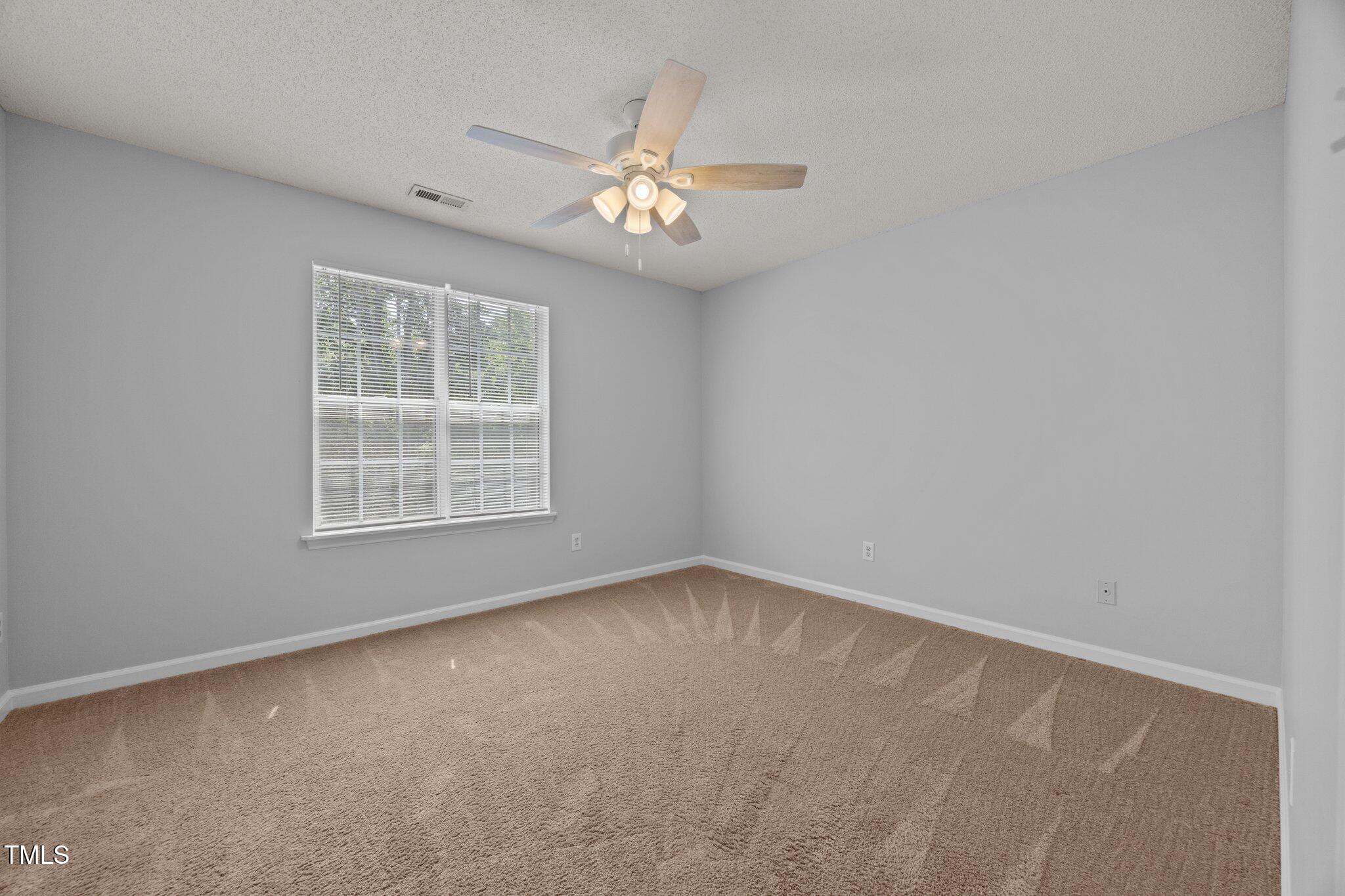 4406 Still Pines Drive Raleigh, NC 27613 - Photo 18 of 39 an empty room with windows and fan
