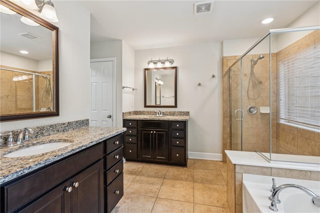 1514 Woodbridge Way Northeast Atlanta, GA 30329 - Photo 32 of 54 a spacious bathroom with a granite countertop sink a mirror a vanity and shower