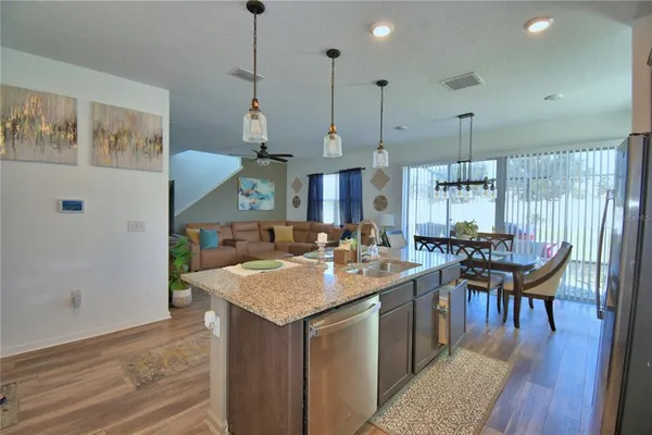 a kitchen with granite countertop a sink a center island stainless steel appliances and cabinets