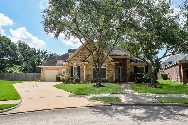 a front view of a house with a garden and trees