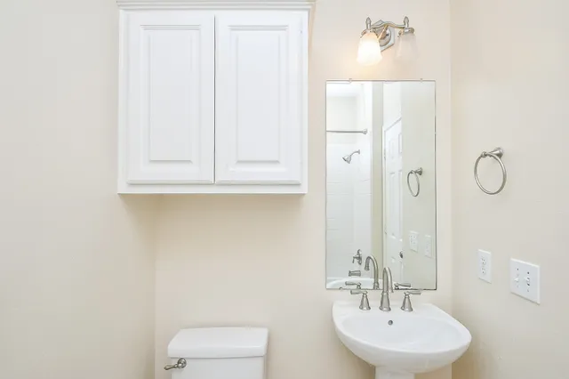 a bathroom with a sink a toilet and mirror
