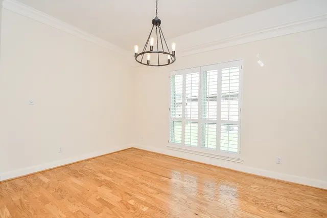 an empty room with windows and chandelier