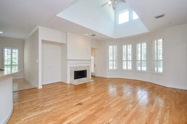 an empty room with wooden floor and fireplace