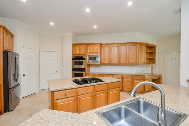 a kitchen with stainless steel appliances granite countertop a sink stove and refrigerator