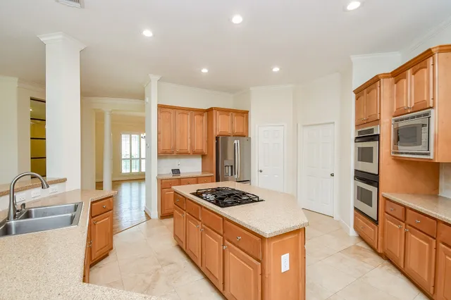 a kitchen with stainless steel appliances granite countertop a sink stove and refrigerator