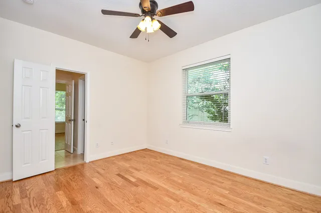 a view of a bedroom with a ceiling fan and a window
