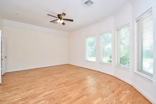 an empty room with a window and a ceiling fan