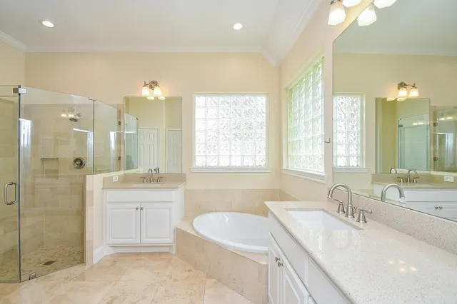 a bathroom with a granite countertop tub sink shower and mirror