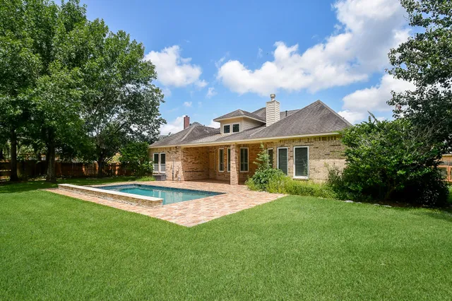 a front view of a house with a yard and trees