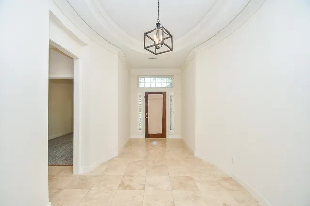 a view of a hallway with a chandelier fan