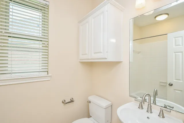a bathroom with a sink a toilet and mirror