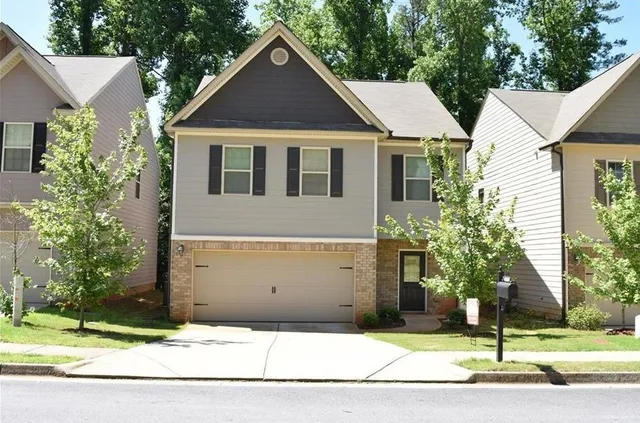 a front view of a house with a yard and garage