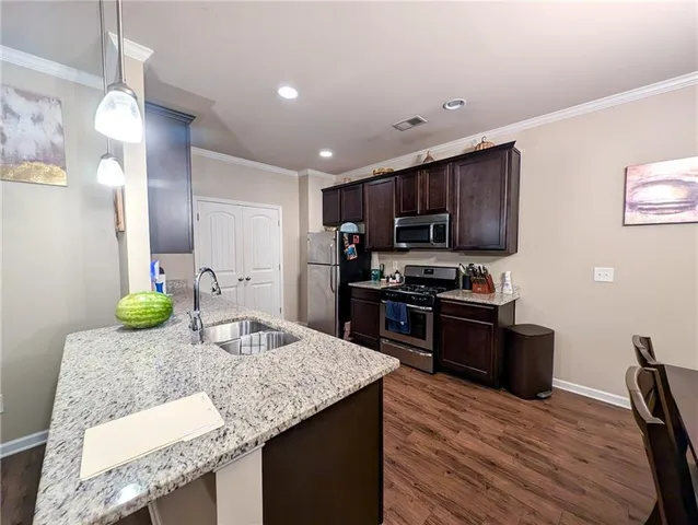a kitchen with granite countertop stainless steel appliances and wooden cabinets