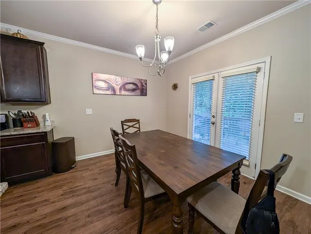a view of a dining room with furniture wooden floor and a chandelier