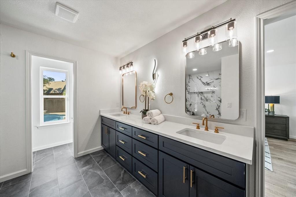 3609 Hidalgo Street Irving, TX 75062 - Photo 30 of 40 a bathroom with a double vanity sink a mirror and a shower