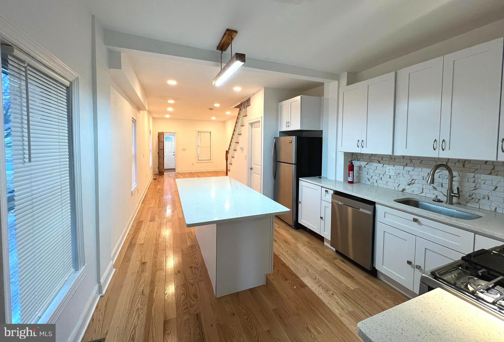 a large kitchen with stainless steel appliances kitchen island granite countertop a stove and a sink
